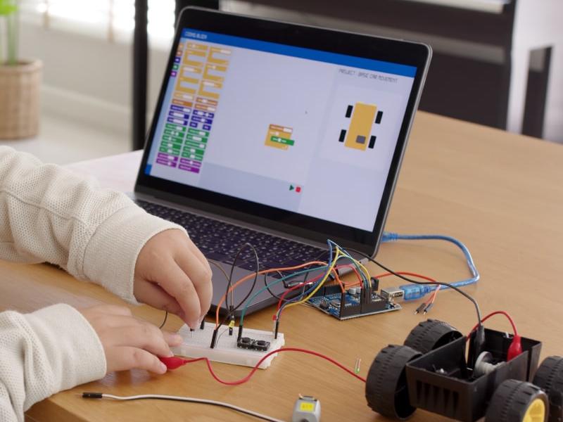 Manos jóvenes programando un robot